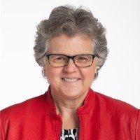 Image of Kathy Greenlee, Health and aging policy expert wearing glasses and red blazer over white and black blouse