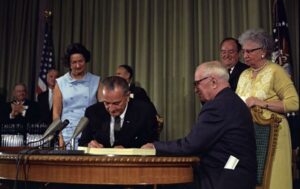 Lyndon Johnson and Hubert Humphrey sign the Medicare Bill in 1965, as former President Truman (left) and his wife Bess, and Lady Bird Johnson in attendance. Source: https://www.thenation.com/article/archive/july-30-1965-lbj-signs-medicare-into-law/